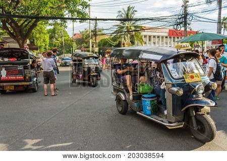 CHIANG MAI THAILAND - 6/13/2015: Tourists ride tuk-tuks around the city.