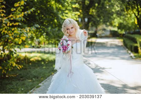 An innocent young bride boasts of her beauty in a city park.