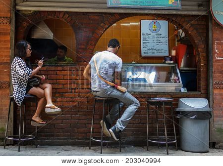 KATHMANDU NEPAL - 9/23/2015: Customers at a small streetside cafe in the Thamel district of Kathmandu Nepal.