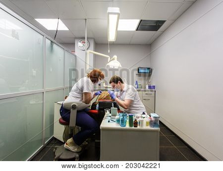 Moscow, Russia. June 2017 The dentist and the assistant work on the patient in the clinic
