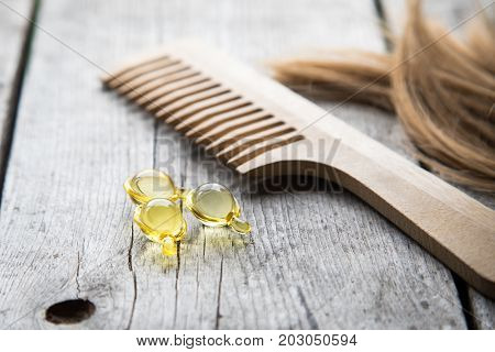 Hair Nurishment. Vitamin Serum Capsule On Wooden Background