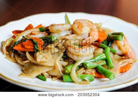 Pad Khee Mao, Stir-fried with wide rice noodles, hot peppers, carrots, green beans, onions, tomato and
sweet basil leaves