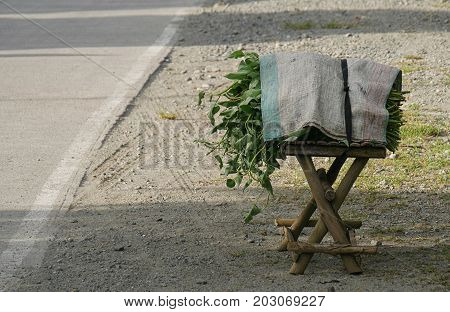 Bunches of kang kung leaves covered by a sack, left on the roadside for sale in a town in the southern Philippines