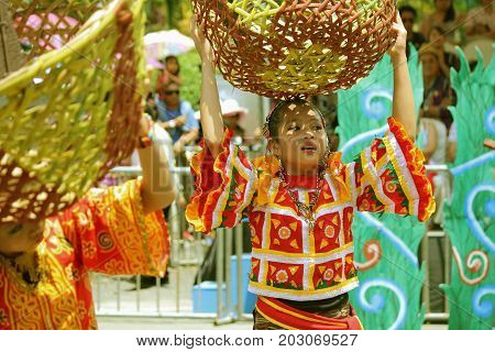 DAVAO CITY, PHILIPPINES--AUGUST 2014: Girls carrying big empty baskets as props at the streetdancing parade.
Kadayawan is celebrated August each year to give thanks for life and an abundant harvest.