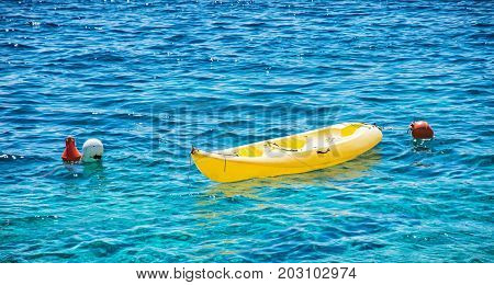 Anchored yellow kayak in Maslinica Solta island Croatia. Summer vacation destination.