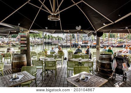 ROTTERDAM, NETHERLANDS - August 05, 2017: Outdoor cafe with people on the Oude haven in Rotterdam old city centre