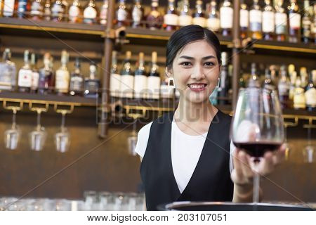 Young Asian Woman Waiter Restaurant Catering Service Happy Emotion. Woman Waiter Present Red-wine Fo