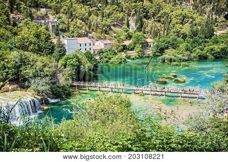 Many tourists are swimming in the river near the waterfalls Krka Croatia national park. Beautiful natural scene. Travel destination. Summer vacation.