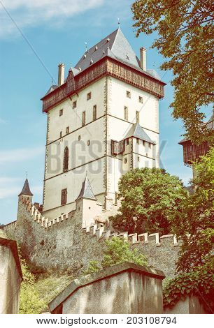 Karlstejn is a large gothic castle founded 1348 by Charles IV in Czech republic. Ancient architecture. Travel destination. Yellow photo filter.