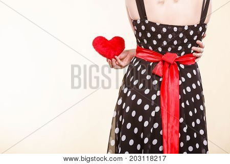 Valentine day gift proof of love romantic present concept. Woman in retro polka dot dress holding small furry red heart