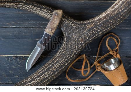 Knife Hunter And Mug On A Black Background.