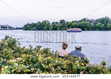 Washington Dc, Usa - August 4, 2017: Couple Sitting In Georgetown Park Harbor On Riverfront In Eveni
