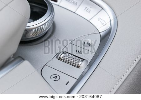 Media and navigation control buttons of a Modern car. Car interior details. White leather interior of the luxury modern car. Modern car interior