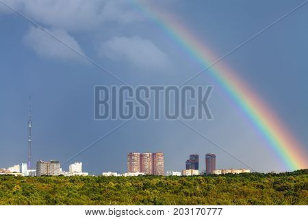 Rainbow In Rainy Sky Over City With Tv Tower