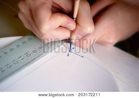 The artist paints an anchor on a white plate made of clay. Painted, handmade