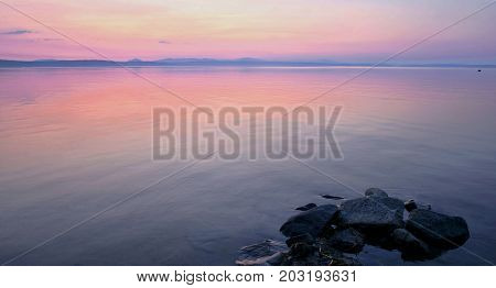 pale pink and blue sunset on the lake, South Ural, Uvildy, in the distance are seen the Ural mountains