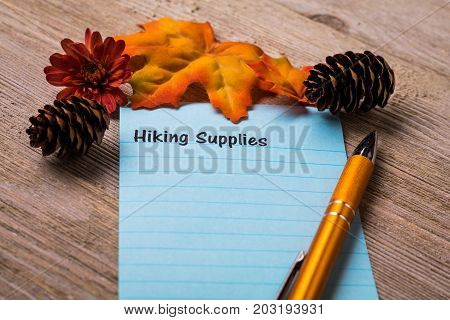 Fall Hiking Supplies list concept on notebook and wooden board