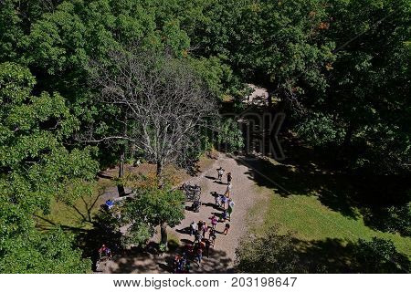 View looking downward on the crowds waiting to climb a fire tower in a forest