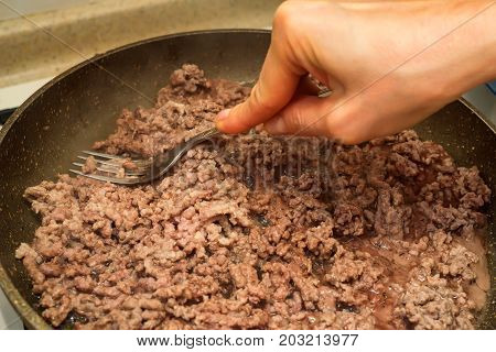 Closeup of minced meat being cooked on skillet