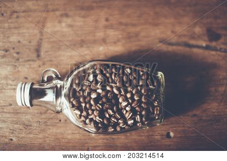 Top Vier of Coffee beans (Peaberry) inside the clear bottle Focus only subject blur backgroundChiangmai Thailand