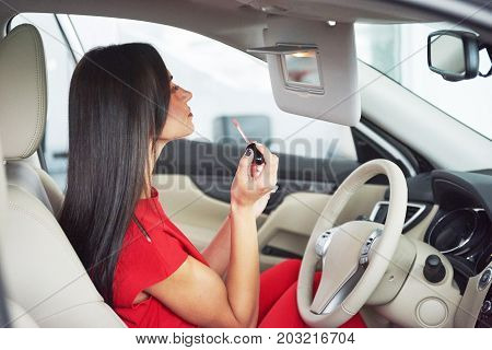 woman in car indoor keeps wheel turning around smiling looking at passengers in back seat idea taxi driver against sunset rays Light shine sky Concept of exam Vehicle - second home the girl.