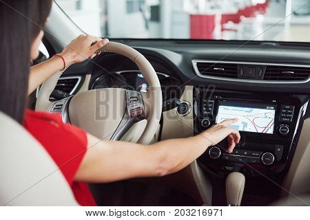 woman in car indoor keeps wheel turning around smiling looking at passengers in back seat idea taxi driver against sunset rays Light shine sky Concept of exam Vehicle - second home the girl.
