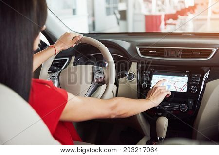 woman in car indoor keeps wheel turning around smiling looking at passengers in back seat idea taxi driver against sunset rays Light shine sky Concept of exam Vehicle - second home the girl.
