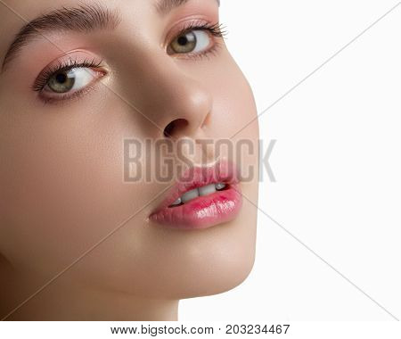 The sensual blonde with a natural day make-up on a white background. Gently pink gloss of lipstick on lips. Spa cosmetology fashion health