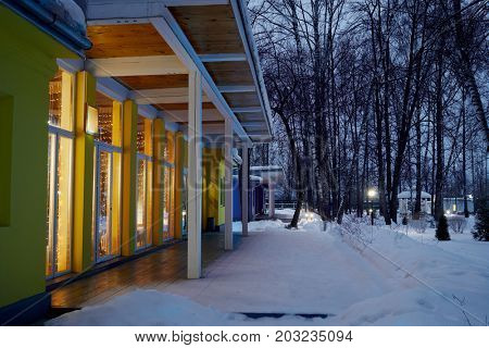 VASILYEVSKOYE, MOSCOW REGION, RUSSIA - FEB 4, 2017: Illuminated one-storeyed holiday hotel in forest on winter morning at Provence-Hotel Four Seasons. 