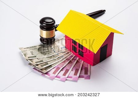 stock photo of india and real estate law, Indian law for real estate / construction company  / architects / builders or buyers showing small house model, gavel / hammer, indian currency notes