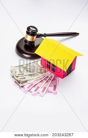 stock photo of india and real estate law, Indian law for real estate / construction company  / architects / builders or buyers showing small house model, gavel / hammer, indian currency notes
