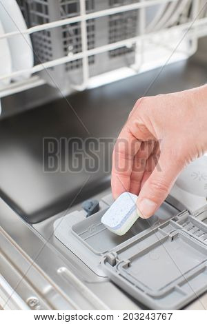 Close Up Of Woman Putting Detergent Tablet Into Dishwater