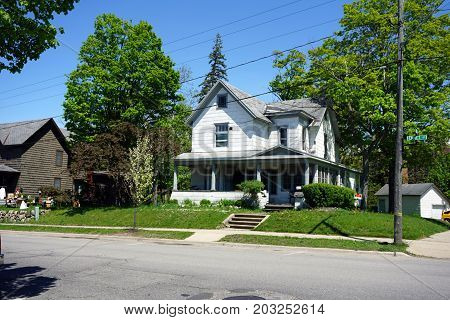 PETOSKEY, MICHIGAN / UNITED STATES - MAY 27, 2017: A white Victorian style home with a front porch, on Emmet Street in Petoskey.