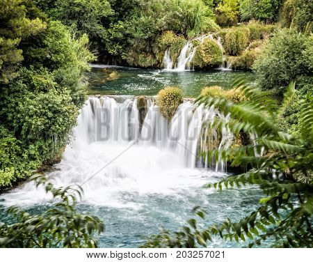 Krka waterfalls. Croatian national park. Beautiful natural scene. Flowing water and greenery.