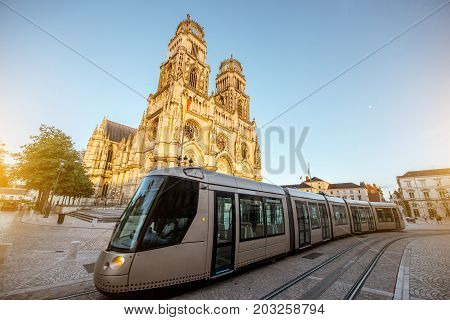 Street view on the saint Croix cathedral with tram in Orleans city during the sunset in central France