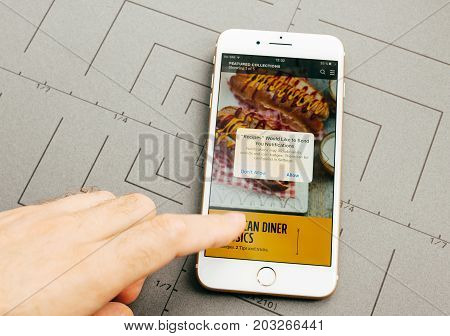 PARIS FRANCE - SEP 26 2016: Male hand holding New Apple iPhone 7 Plus after unboxing and testing by installing the app application software food app by Jamie Oliver