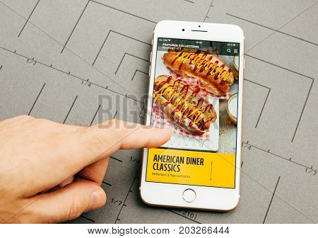 PARIS FRANCE - SEP 26 2016: Male hand holding New Apple iPhone 7 Plus after unboxing and testing by installing the app application software food app by Jamie Oliver
