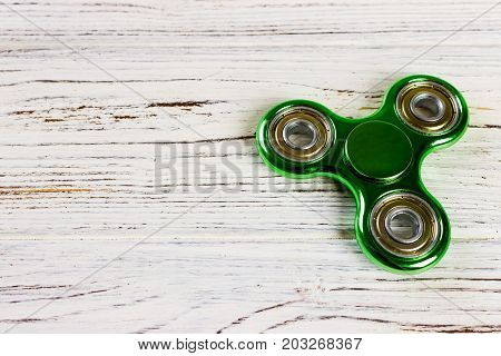 Spinner fidget toy for stress relieving on wood table background with copy space for your creative design project.