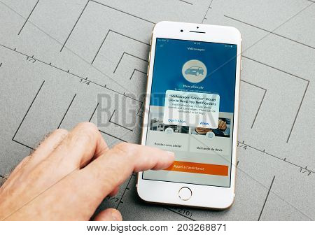 PARIS FRANCE - SEP 26 2016: Male hand holding New Apple iPhone 7 Plus after unboxing and testing by installing the app application software Volkswagen car service app