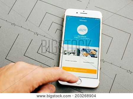 PARIS FRANCE - SEP 26 2016: Male hand holding New Apple iPhone 7 Plus after unboxing and testing by installing the app application software Volkswagen car service app