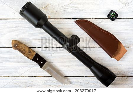 Optical Sight And Hunting Knife On A White Background.