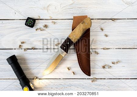 The Knife, The Compass And The Illuminated Flashlight Against The Scattered Bullets.
