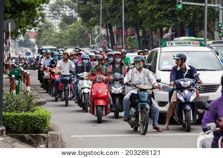 HO CHI MINH CITY (SAIGON), VIETNAM - JULY 2017 : Road traffic in Saigon, Vietnam. In the biggest city in Southern Vietnam are more than 4 mil. motorbikes, the traffic is often congested