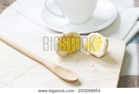 Dessert Chinese pastry or mooncake for Chinese new year with coffee cup on wood desk background. Baking ingredients for homemade making the dough with salted egg yolk and a scented candle.