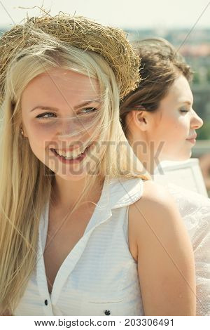Happy girl smiling with straw wreath on head with long blond hair on sunny day on naural background. Fashion and beauty. Summer vacation concept