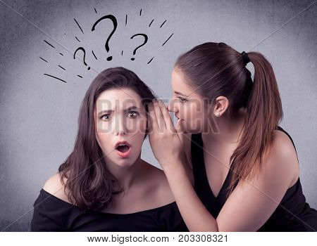 A teenager girl looking confused with drawn question marks above the head, while a girlfriend whispers something in her ear concept.