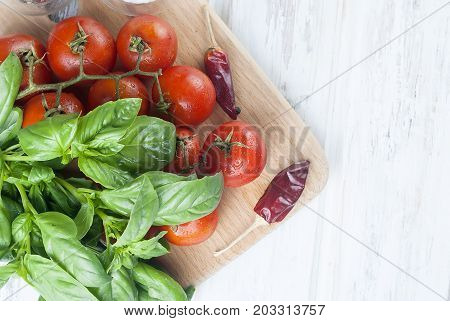 Tomatoes And Bunch Of Fresh Green Basil On A  Wood Background,