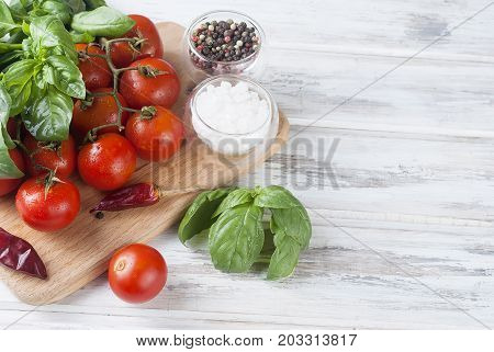 Tomatoes And Bunch Of Fresh Green Basil On A  Wood Background,