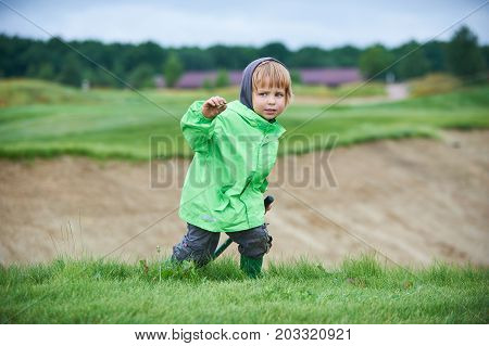 little boy walking the green golf course