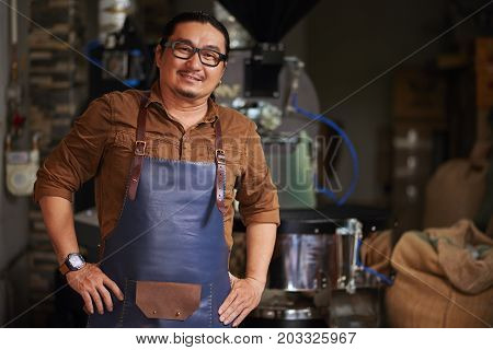 Confident Asian businessman standing in his roastery